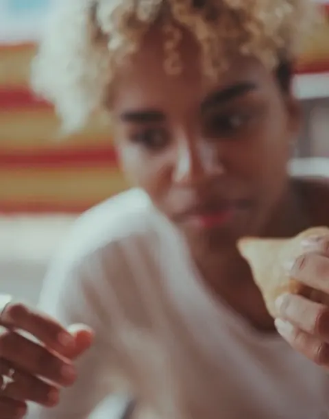 Mulher comendo um salgado